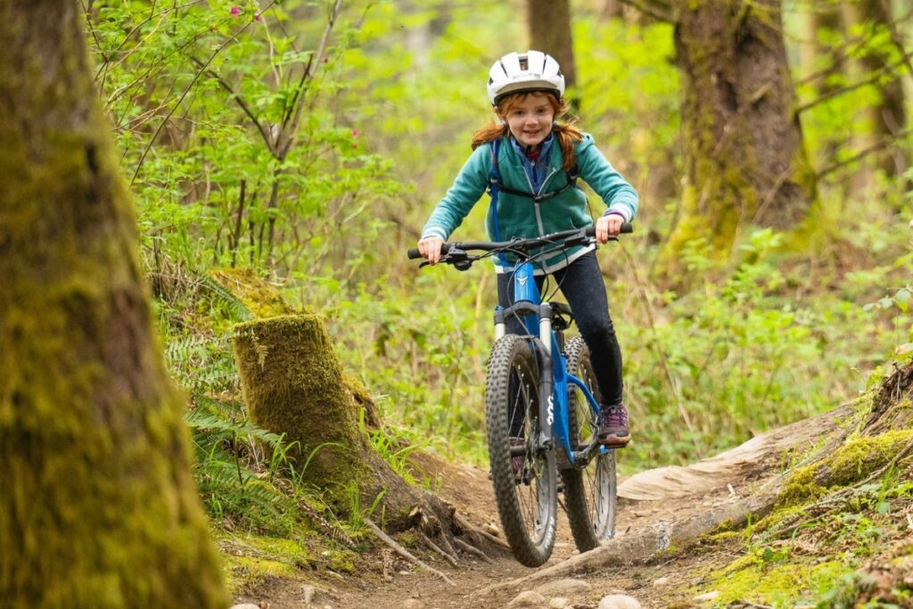 A child riding a Prevelo bike in the forest