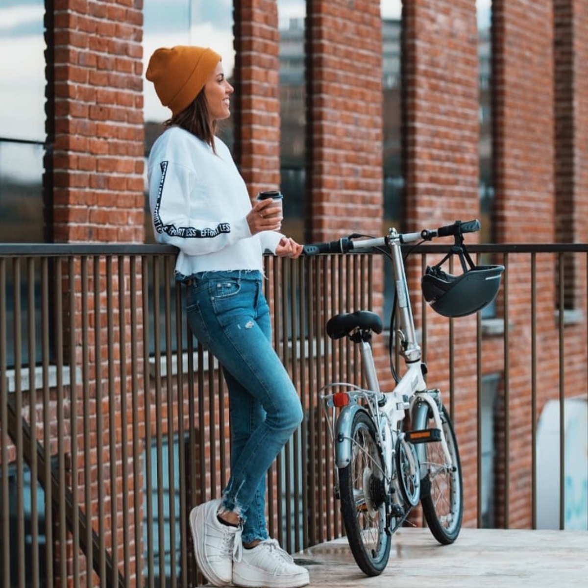 Woman standing with bicycle and Unit 1 Faro Smart Helmet