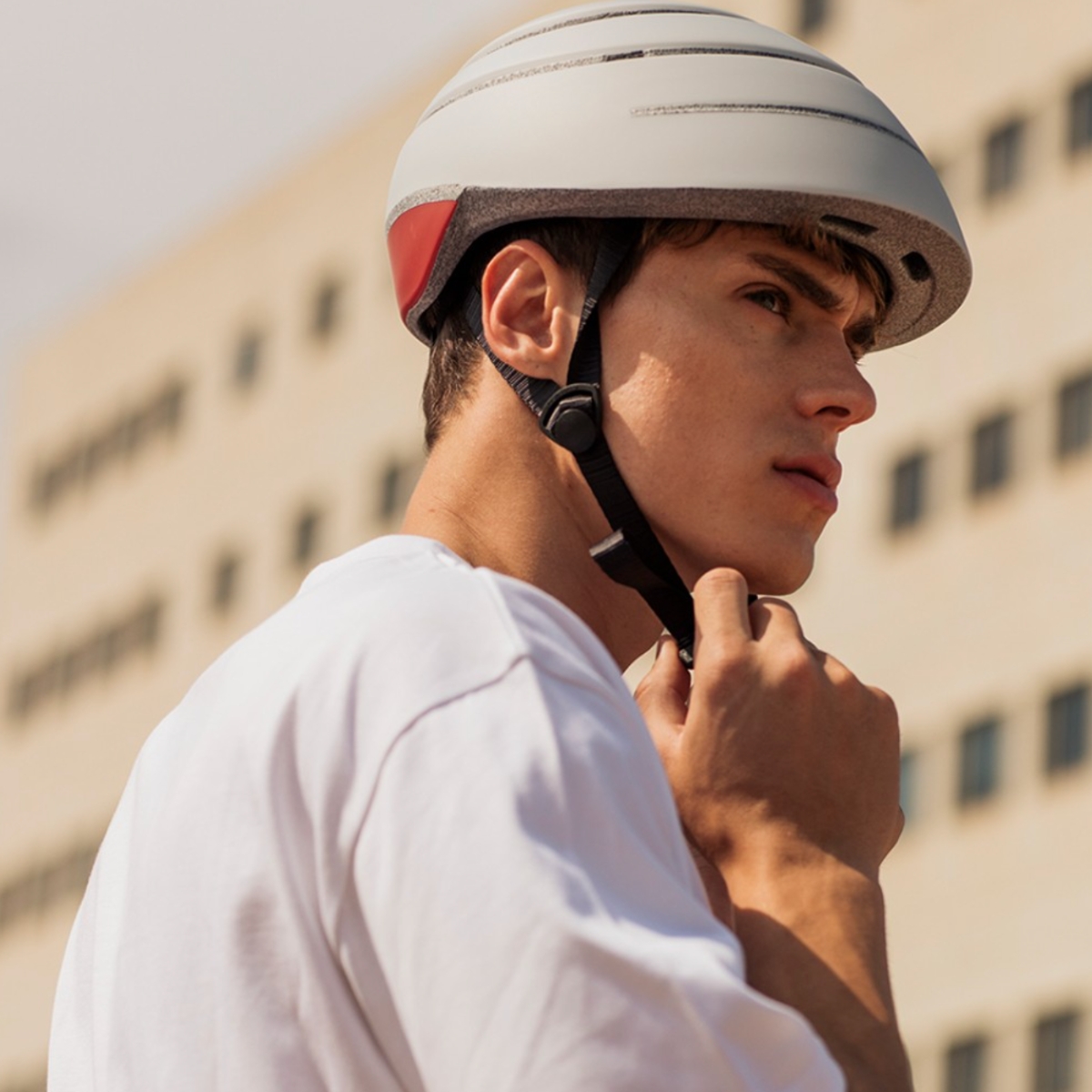 Man adjusting Closca bike helmet chin strap