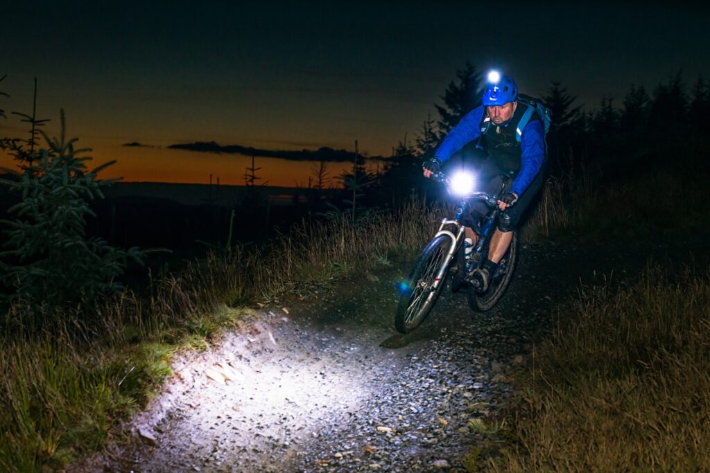 Man cycling at night with headlamp