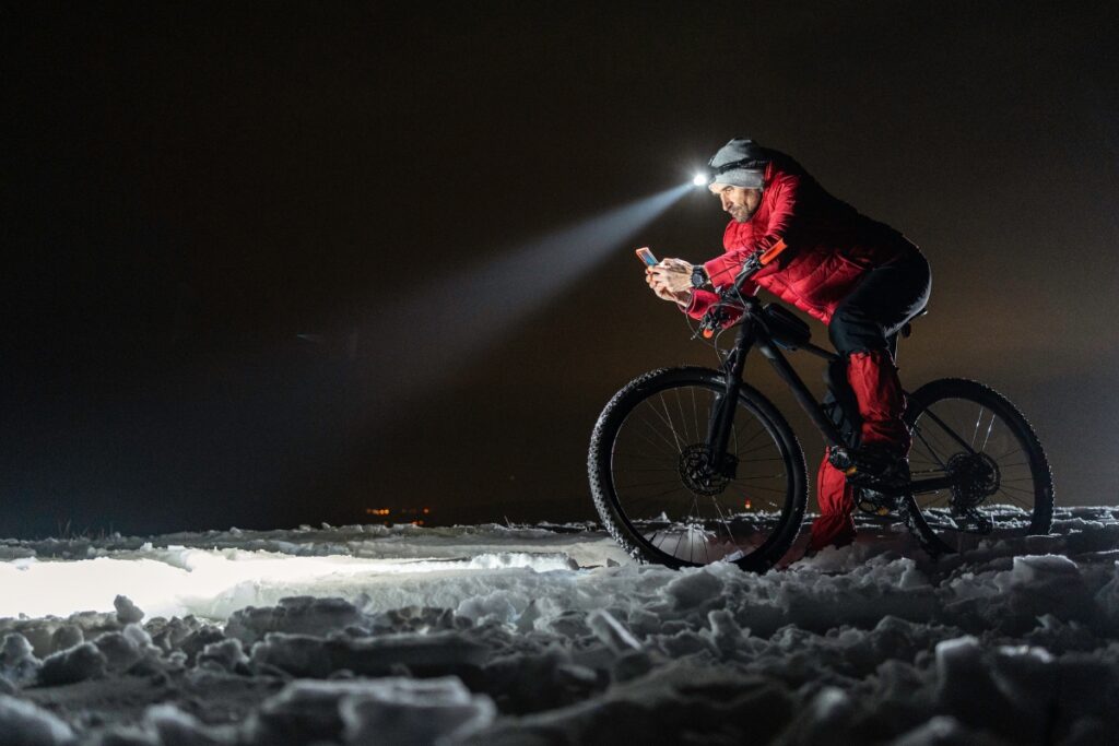 man in red with bike at night