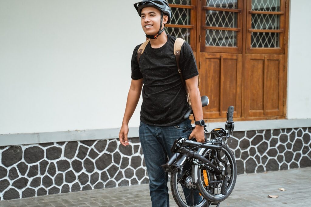 Man carrying a lightweight foldable bike
