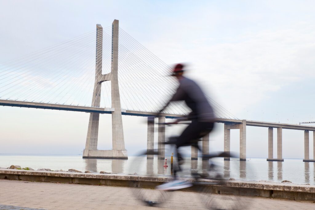 Cyclist in front of Vasco Da Gama Bridge in Lisbon