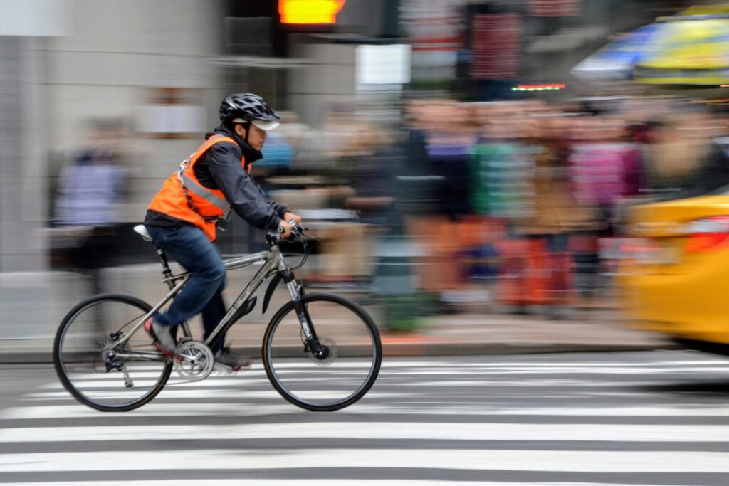 Cyclist with helmet and high-visibility vest. 