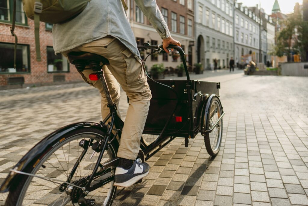 A man riding a cargo bike down a street