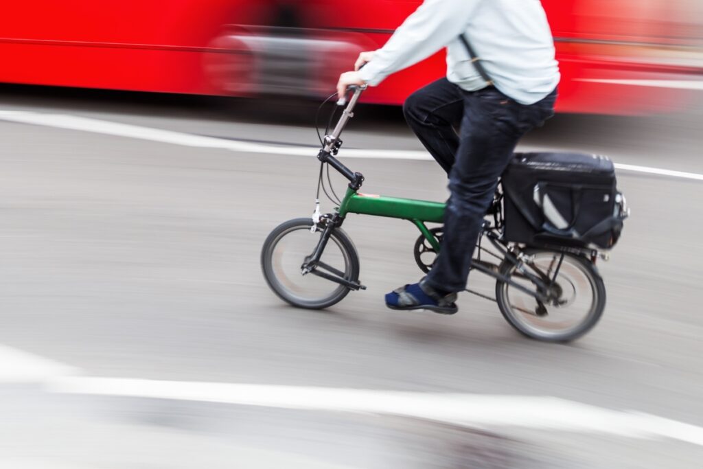 A person riding a folding bike in the city